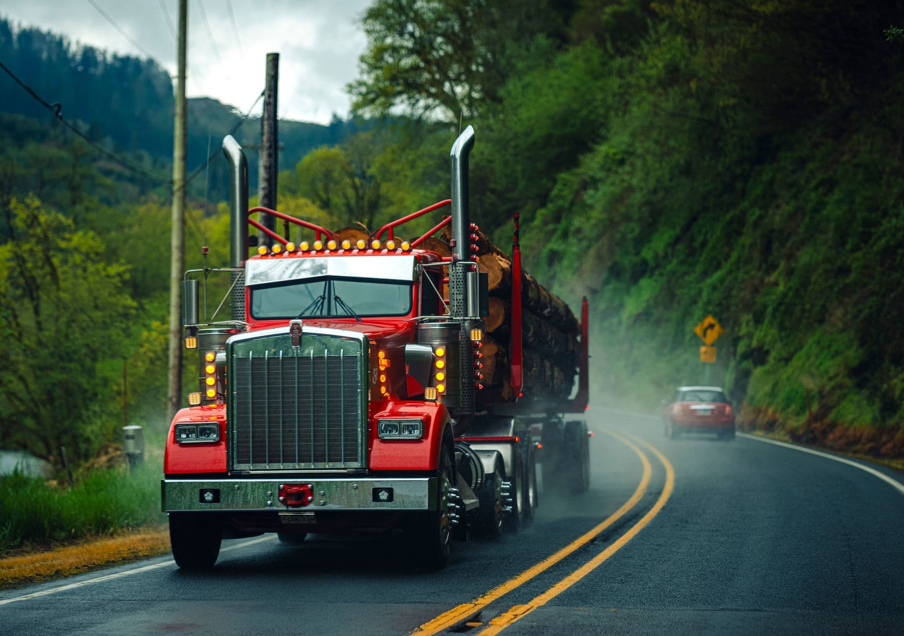 Loaded flatbed truck on a misty forest highway